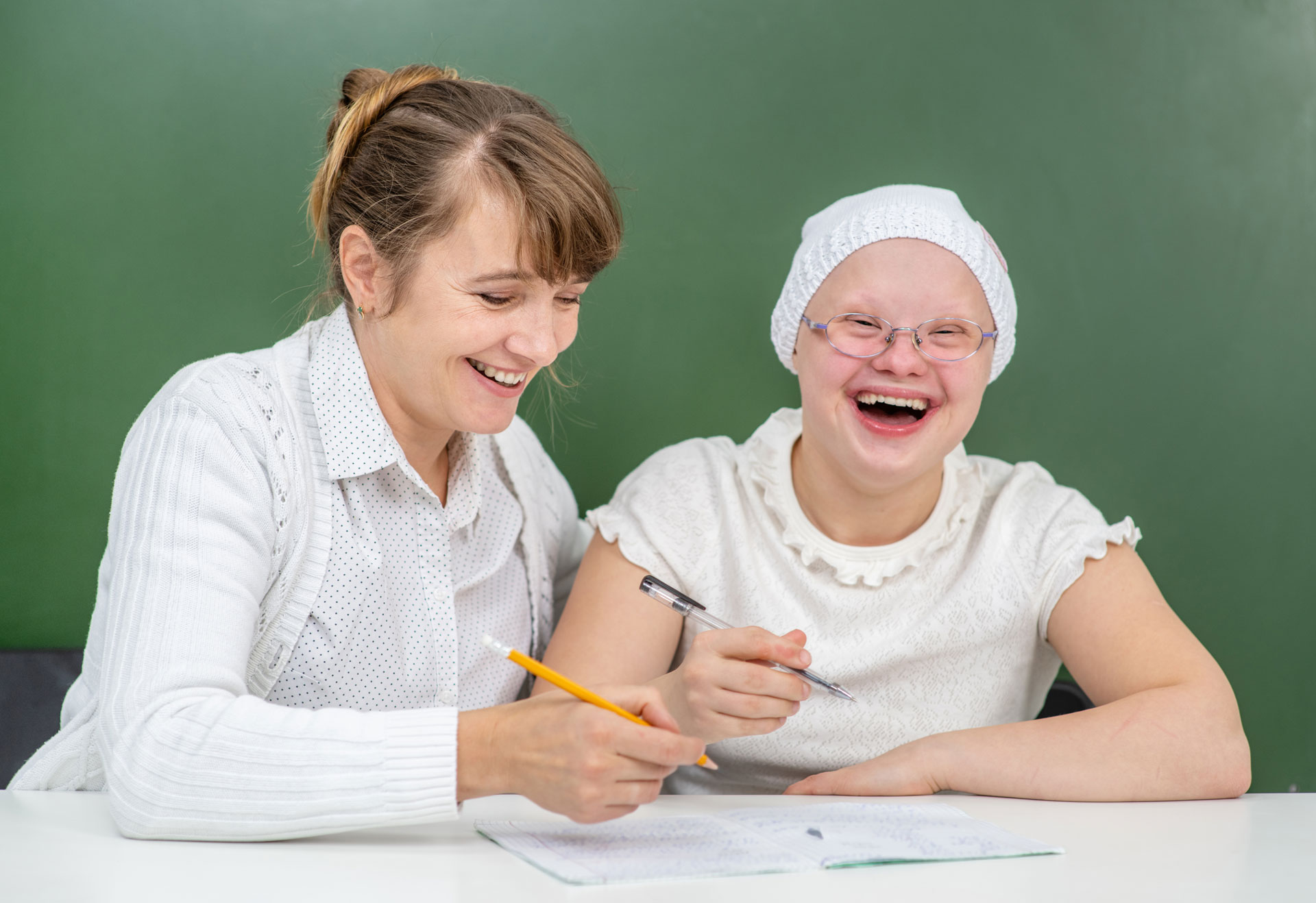 teacher helping special needs girl with down syndrome learn