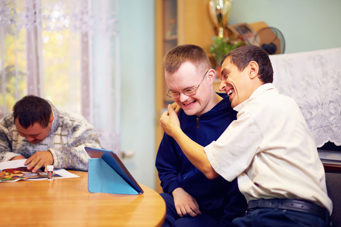 happy special needs adults hugging at a group home