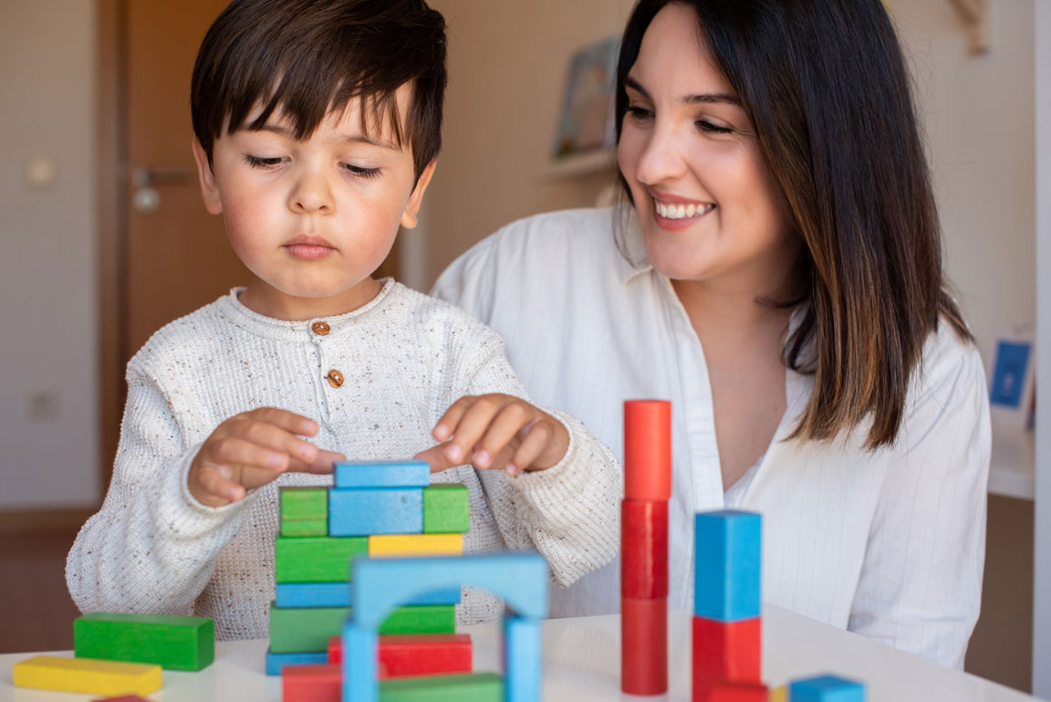 boy and his mom using building blocks