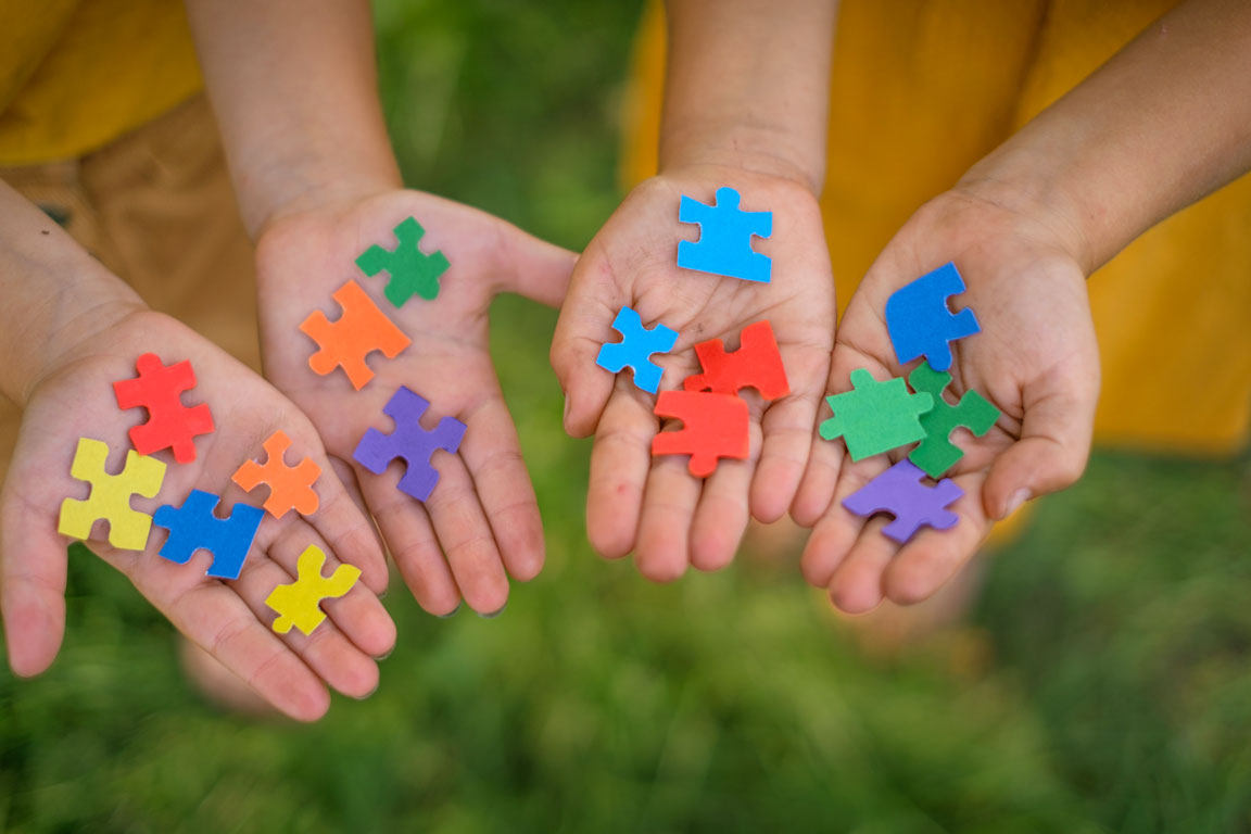 Autism awareness puzzle pieces in children's hands