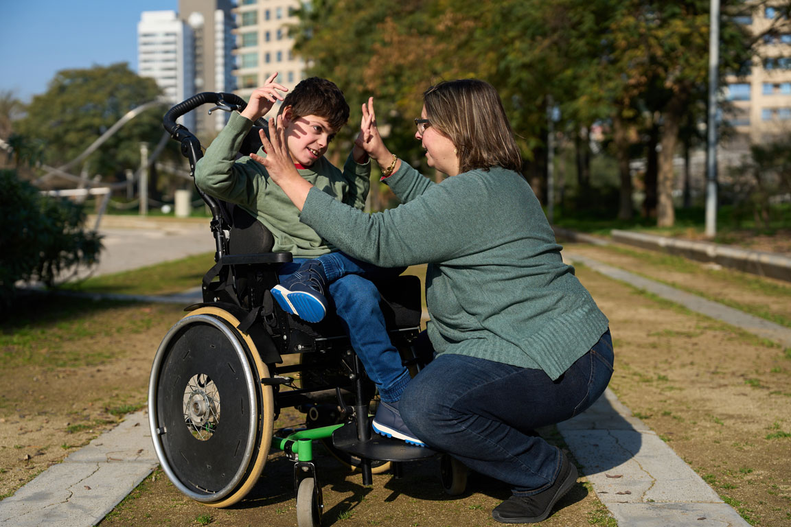 boy with disability outside with mother
