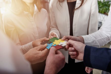 group of people holding puzzle pieces
