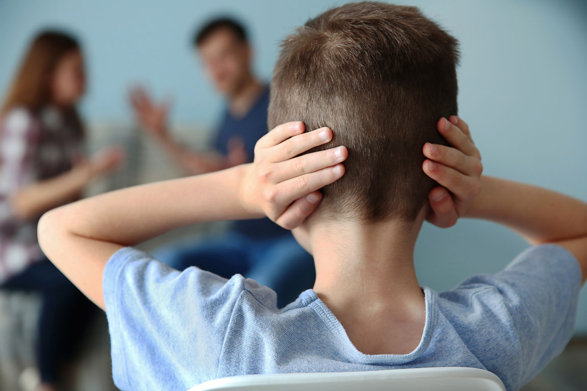 autistic child holding hands over ears